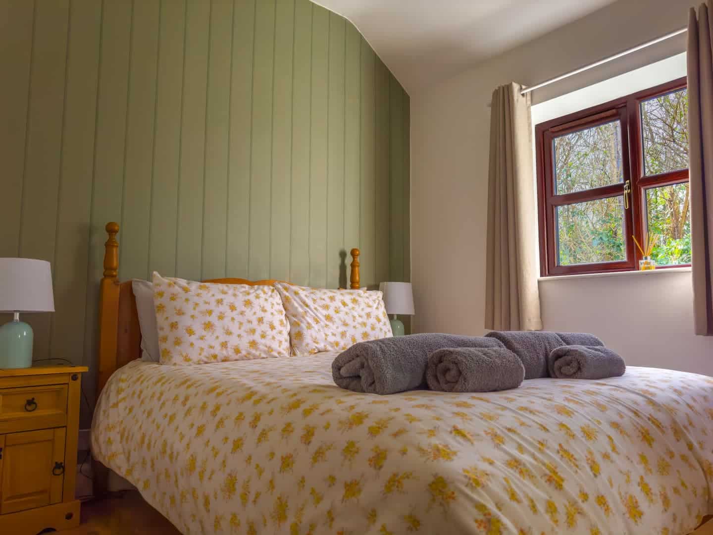 A king-size bedroom with garden views at Priory View Cottage